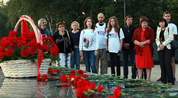 В обрамлении гвоздик и поминальных свечей